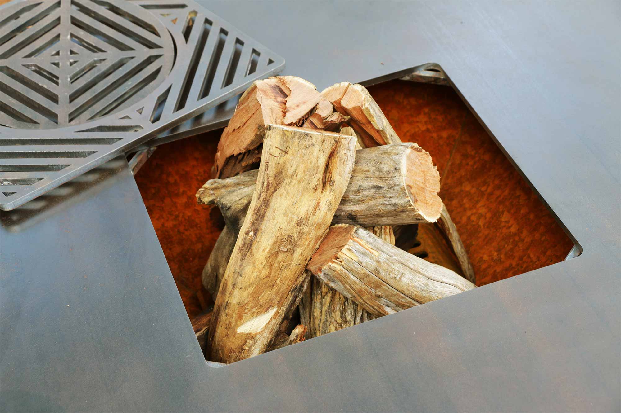 Chad-O-Chef Boma woodfire braai with central aperture, showcasing its sturdy metal construction and open cooking area.