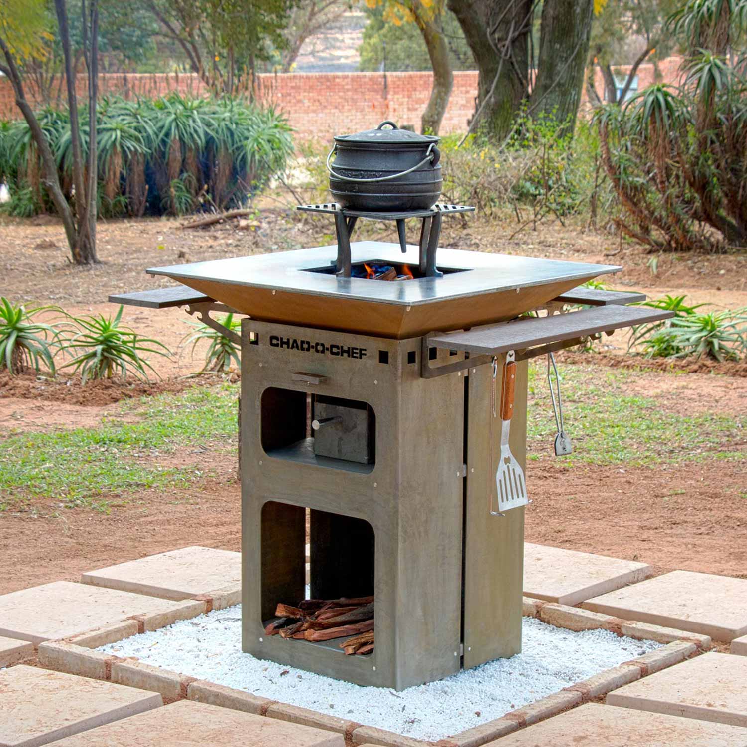 Chad-O-Chef Boma woodfire braai with outdoor setup, showcasing its sturdy design and spacious cooking surface for grilling and barbecuing.