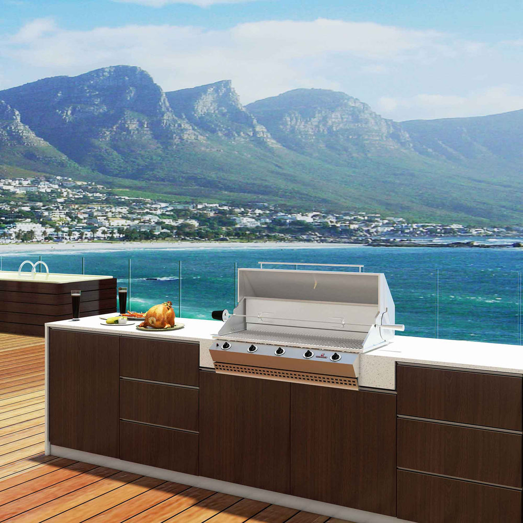 Chad-O-Chef Sizzler braai in outdoor cooking setting with grilling area and accessories visible.