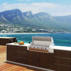 Chad-O-Chef Sizzler braai in outdoor cooking setting with grilling area and accessories visible.