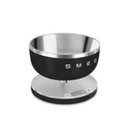 Smeg Digital Kitchen Scale with black and white design, digital display, and stainless steel weighing surface.