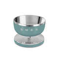 Smeg digital kitchen scale with sleek white design, featuring a digital display and stainless steel weighing platform.