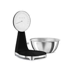 Smeg digital and analog kitchen scale with a sleek white design, featuring a digital display and analog dial for precise measurements.