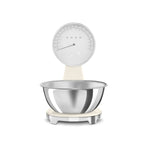 Smeg digital and analog kitchen scale with a sleek white design, featuring a digital display and a classic analog dial.