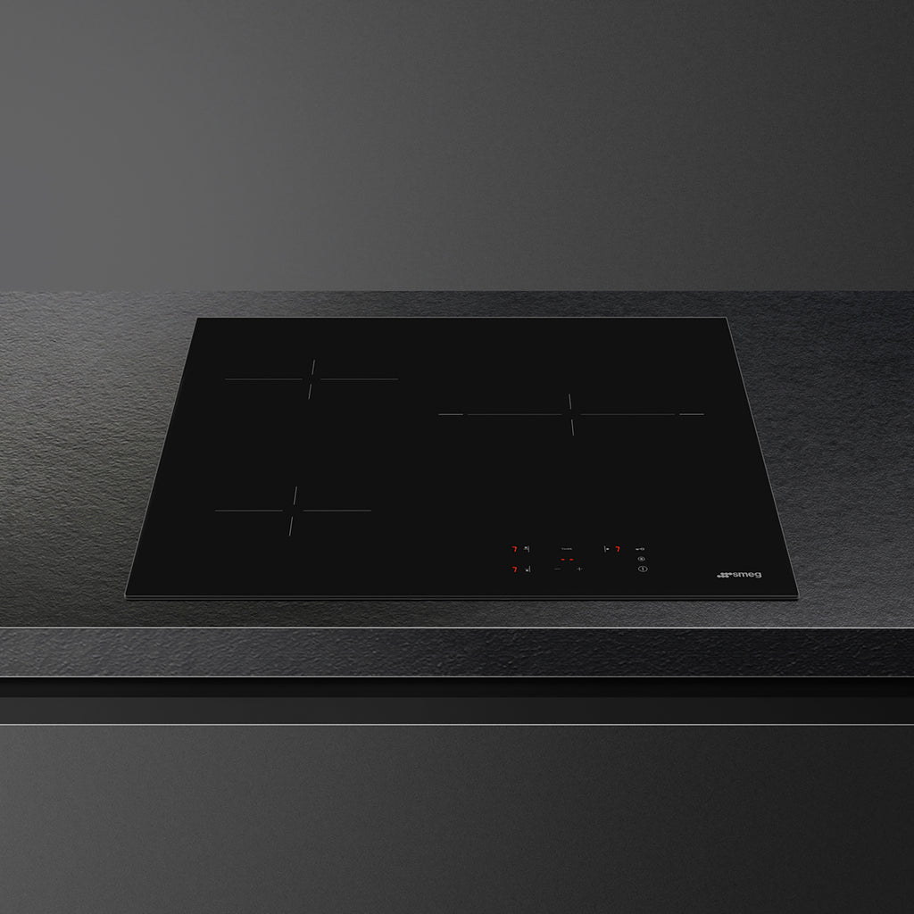 Smeg 60cm Ceran hob with four cooking zones and sleek black glass surface, installed in modern kitchen setting