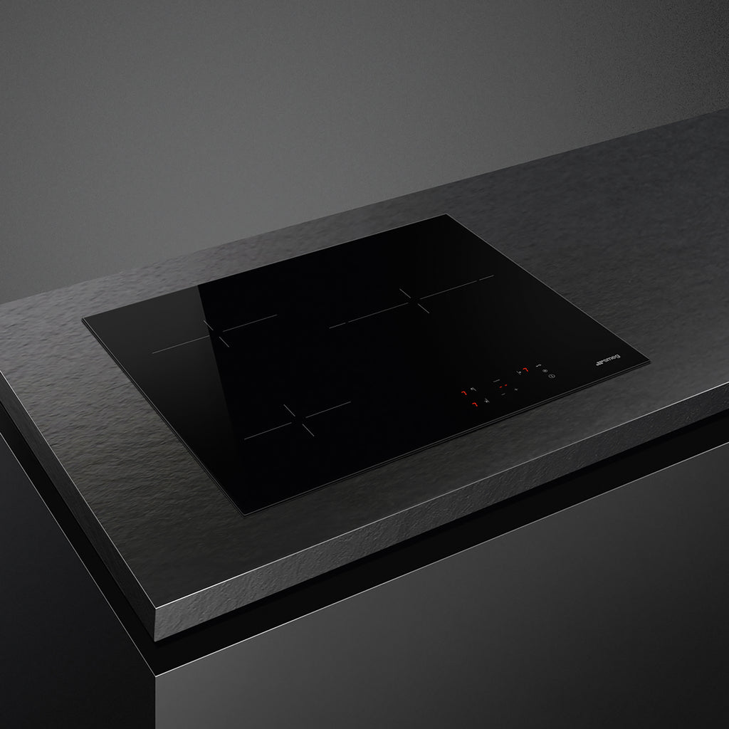 Smeg 60cm Ceran hob with four cooking zones and sleek black surface, installed in a modern kitchen setup.